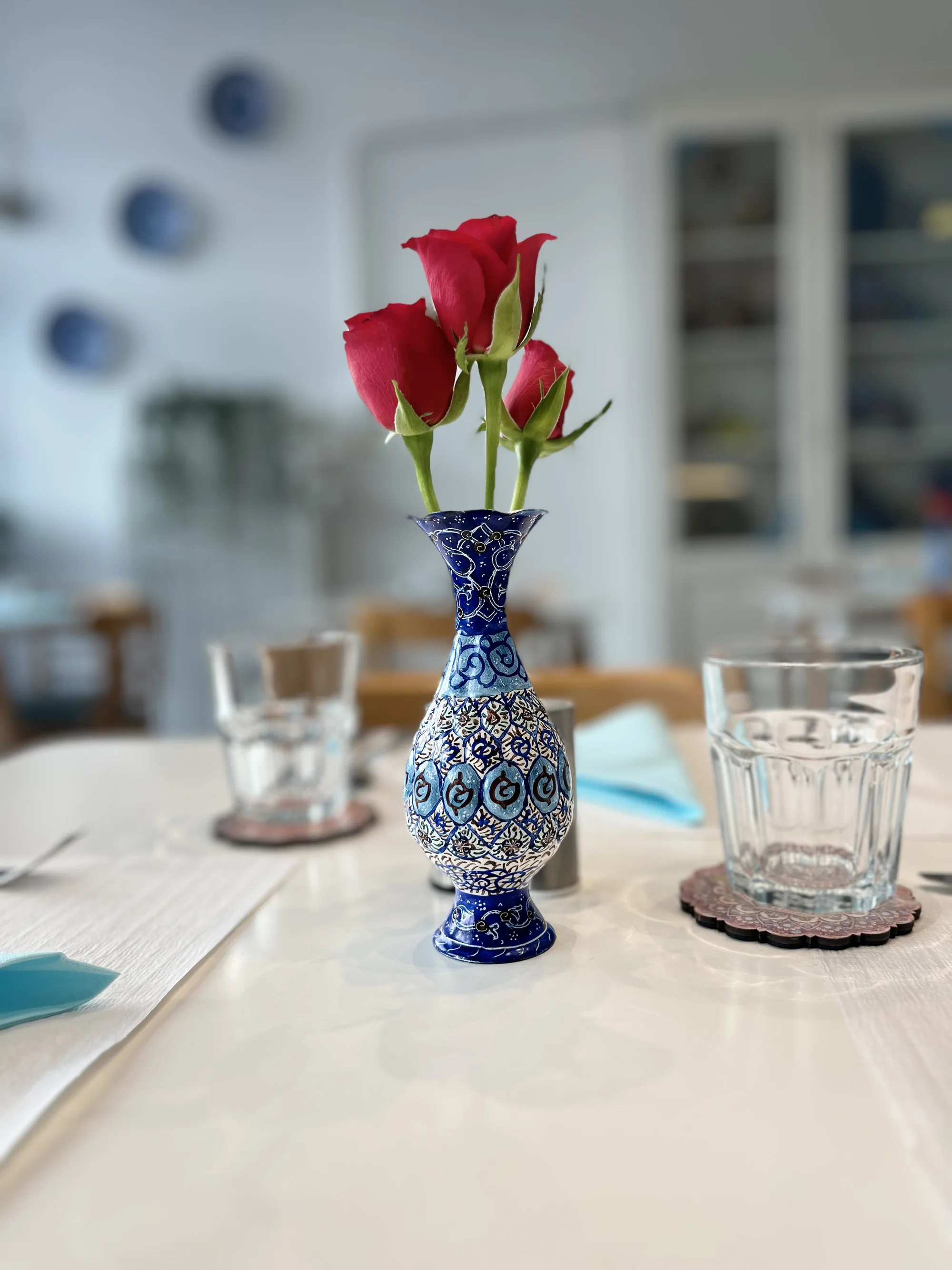 Détail de table Little Persia — roses et céramique bleue